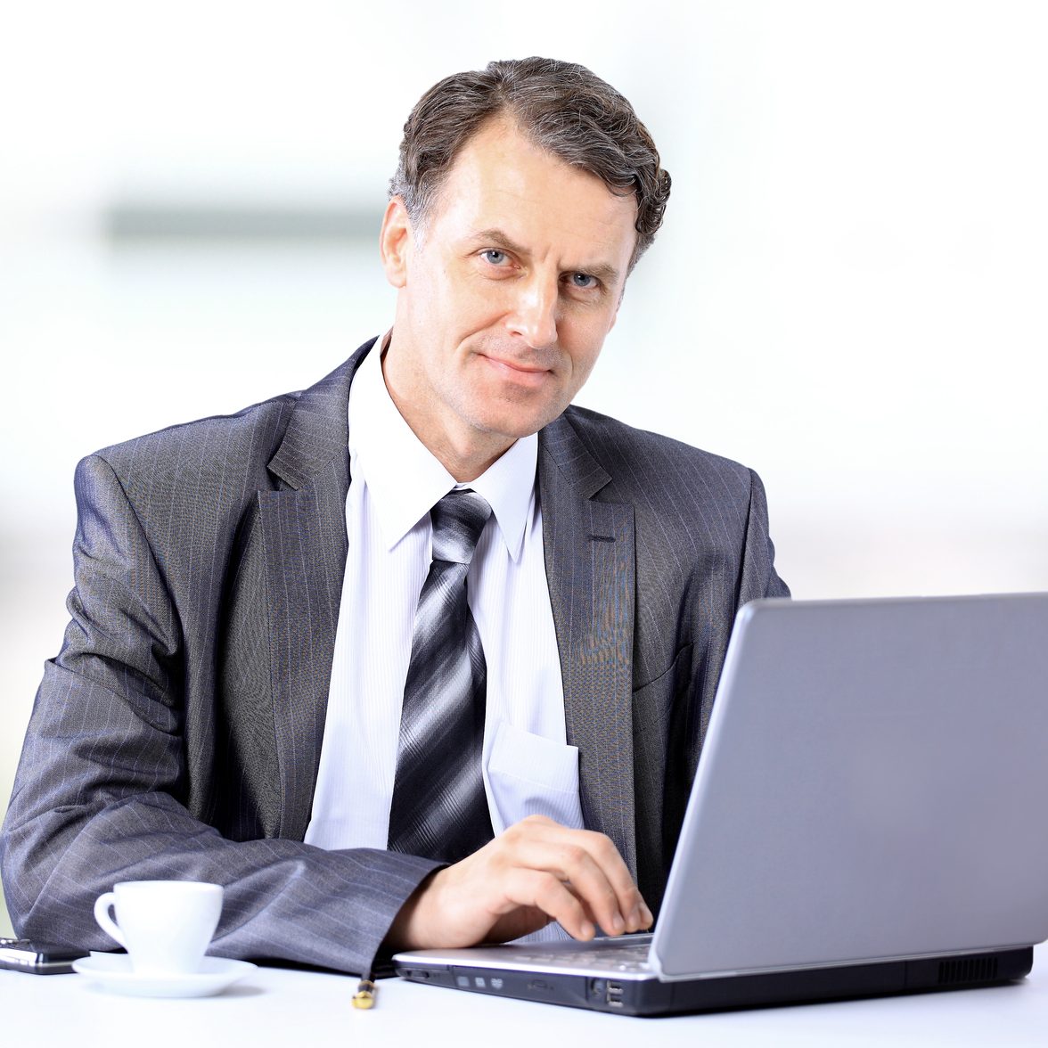 Businessman sitting at desk and working with laptop computer.